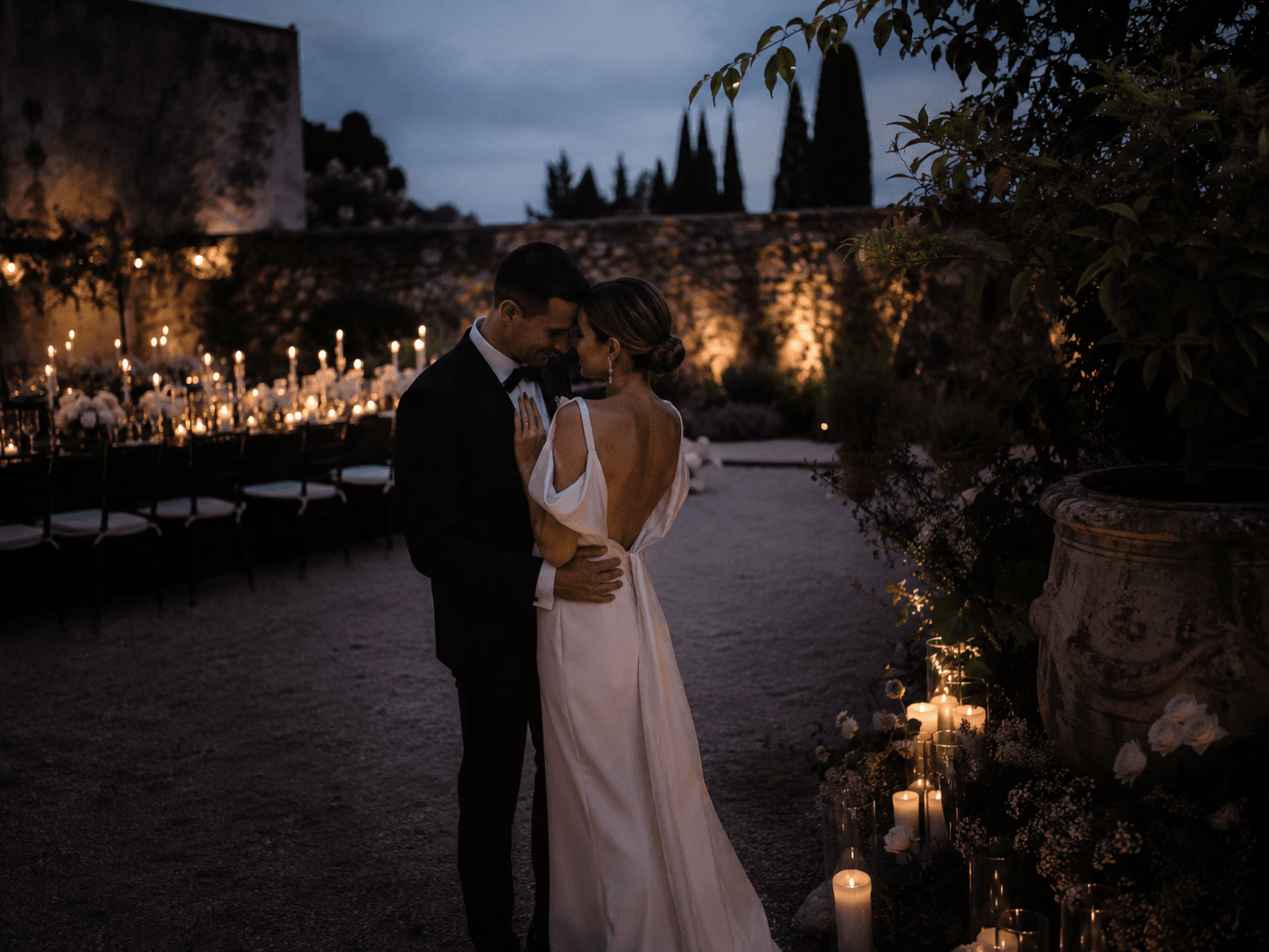 Una pareja de recién casados pasea por un jardín después de la ceremonia